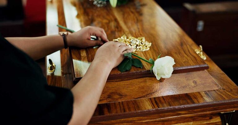 Family members organizing old photos, letters, and memorabilia at a kitchen table.